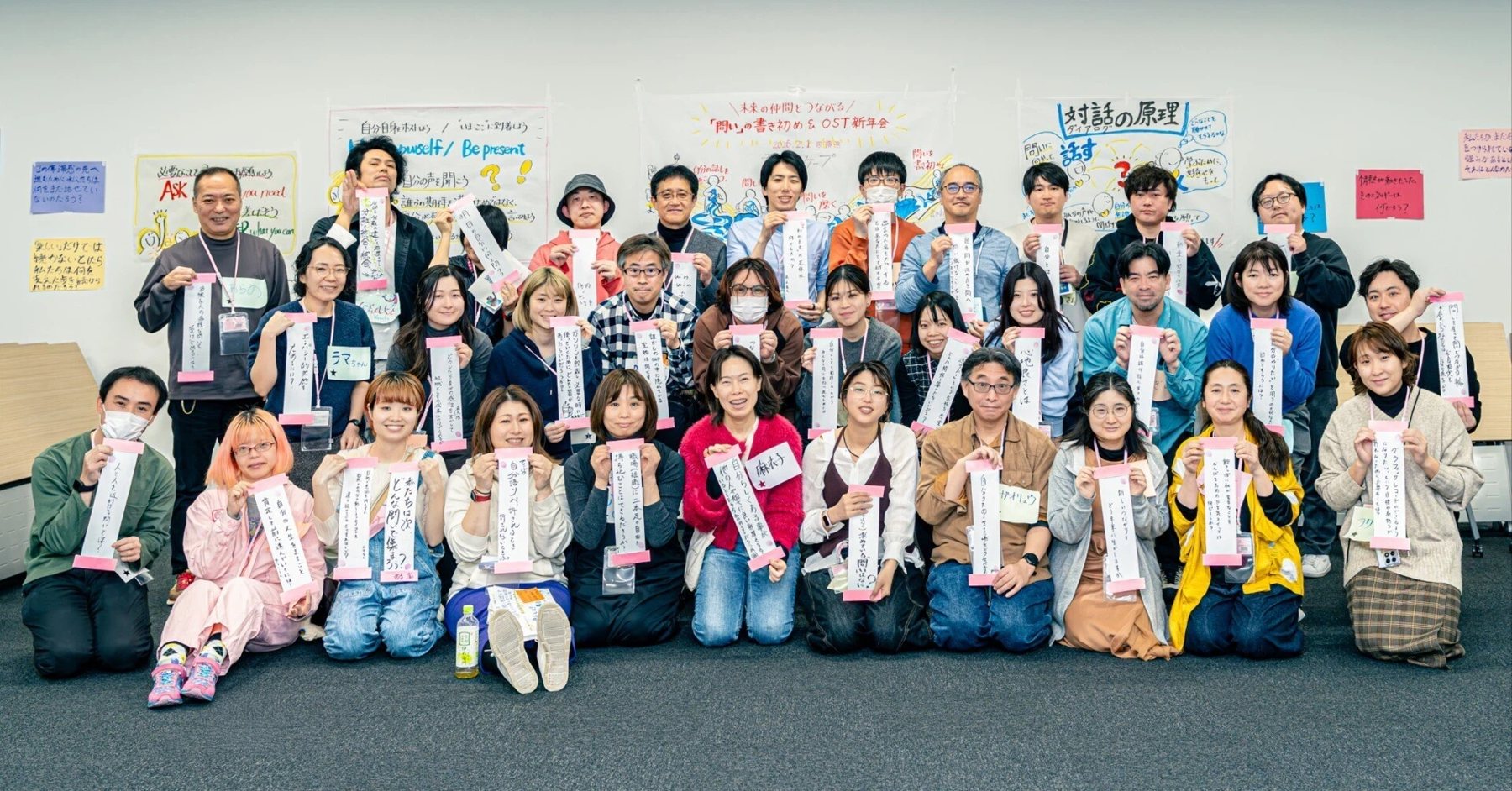 書き初めの問いを手にした参加者の集合写真